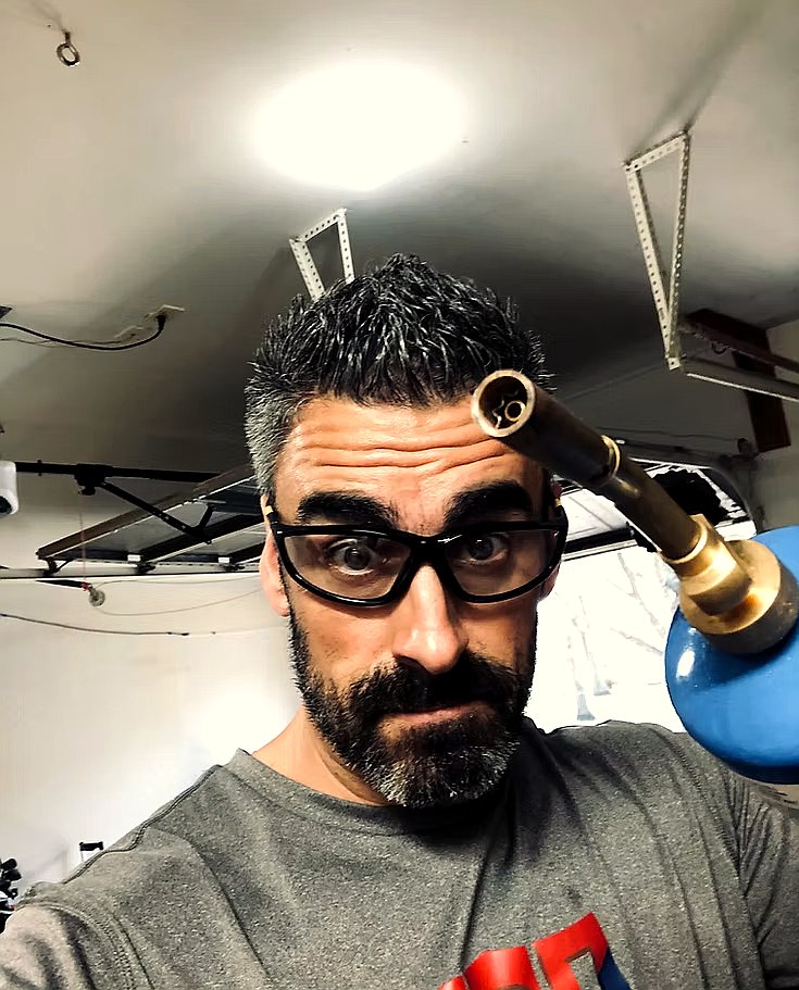 Jason Browne working on a brass instrument in his repair shop